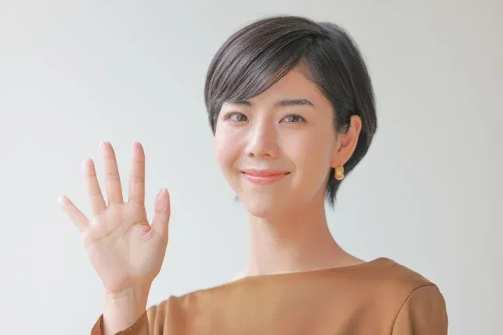 手で五つと表現する女性
