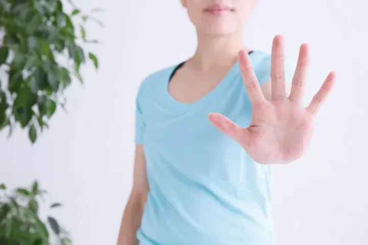 手でストップする女性