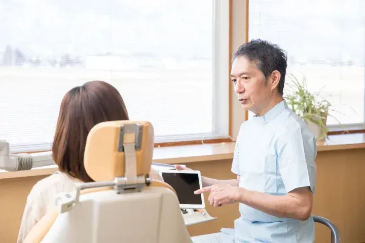 治療の説明をする歯科医