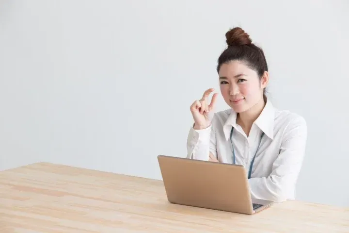 指で少しというポーズをする女性