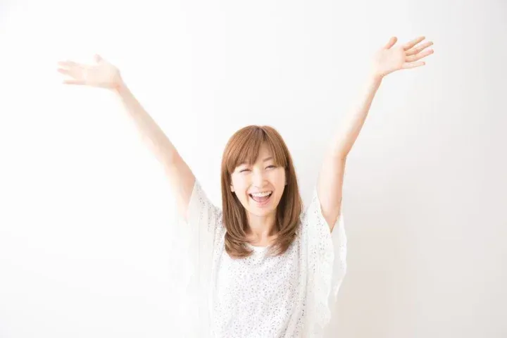 手を上げて喜ぶ女性