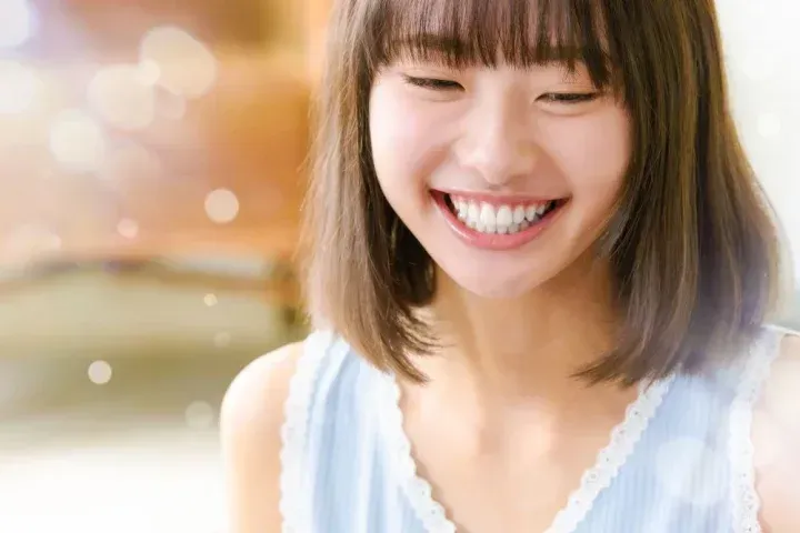 歯を出して笑う女性