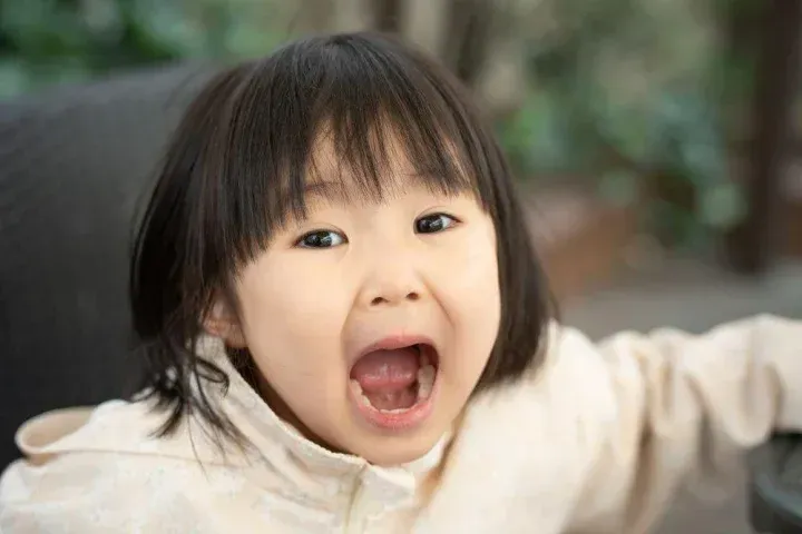 口を大きく開ける幼い子供